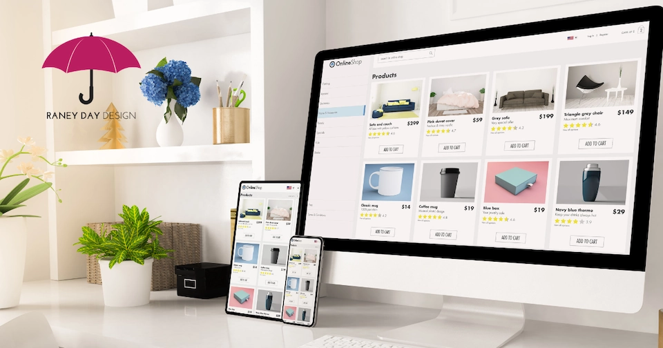 A desktop monitor and tablet display a responsive e-commerce product page for 'Online Shop,' showing items such as sofas, a duvet cover, mugs, and a blue box with prices and 'Add to Cart' buttons. The devices sit on a white desk alongside a potted plant, wicker basket, and storage box. A shelf in the background holds blue hydrangeas, pencils, and decorative accents.